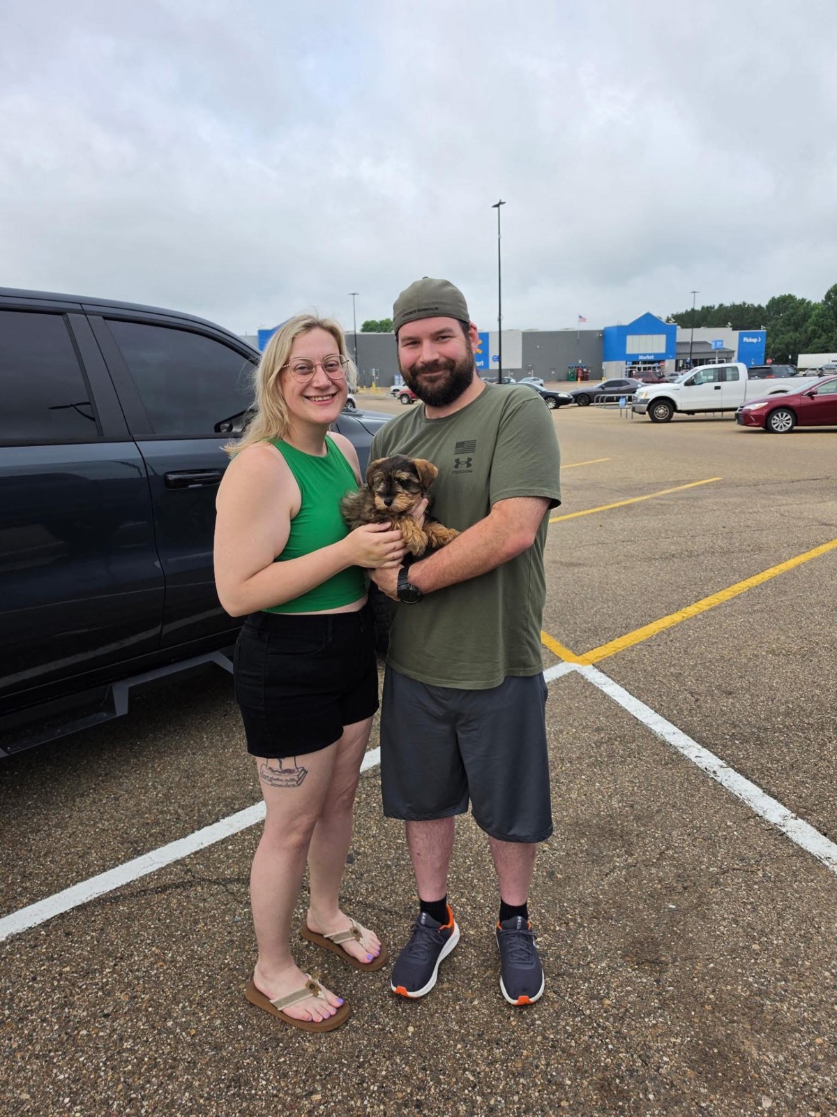 Rocky, a sable Miniature Schnauzer puppy, being held by his new family